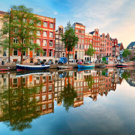 Beautiful Amsterdam sunset. Typical old dutch houses on the bridge and canals in spring, Netherlands